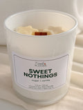 A white glass candle with a label that says "Sweet Nothings" along with the scent notes of sugar and vanilla.