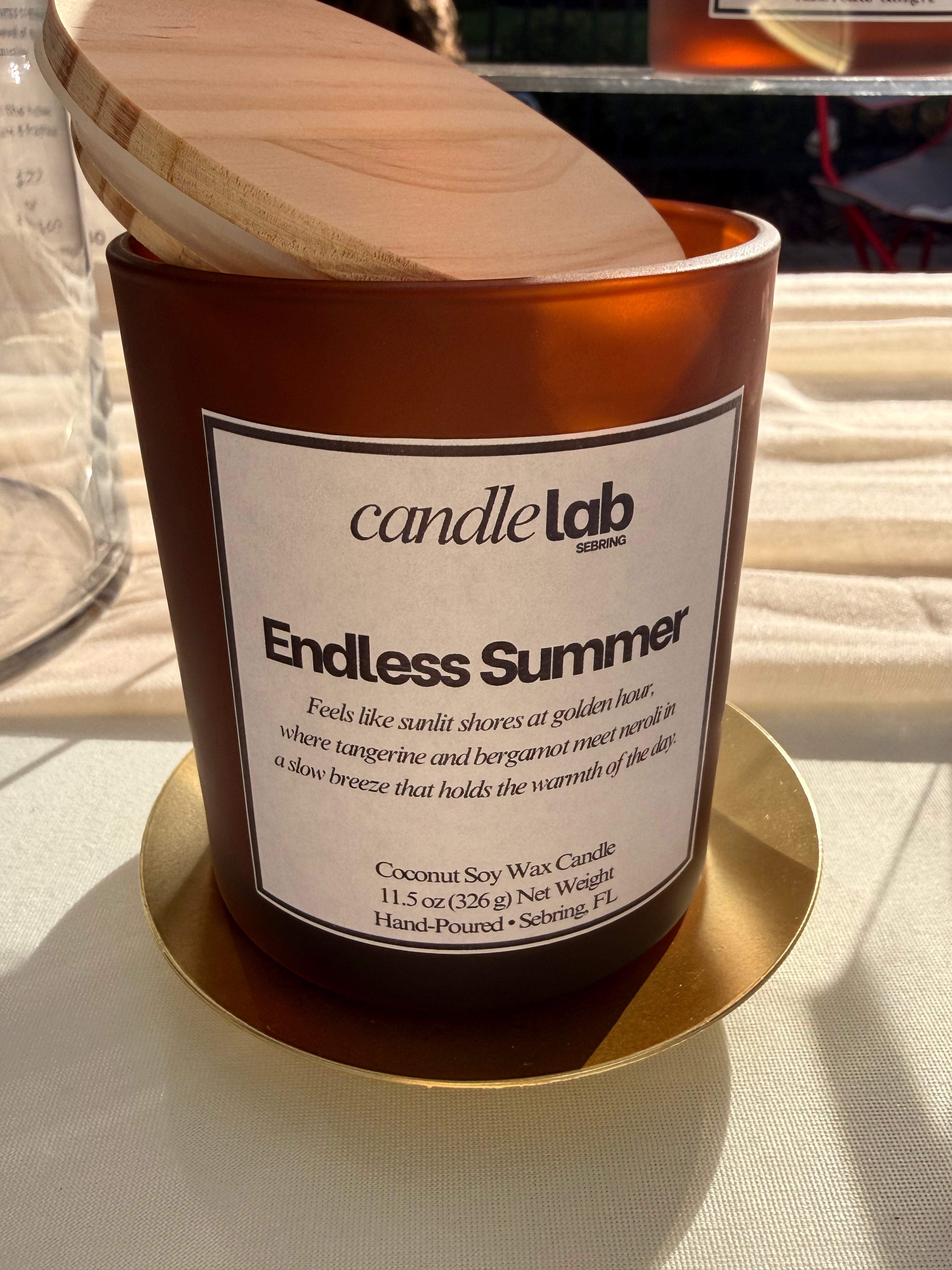 An amber glass candle with a label that says "Endless Summer."