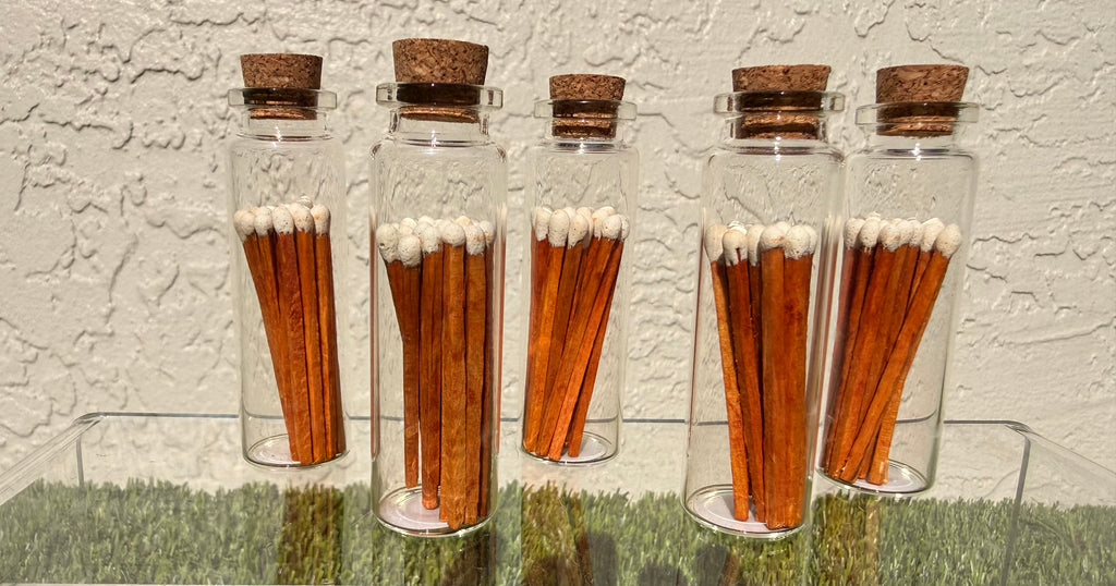 A picture of five glass jars of twenty matches each with a cork top.