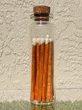 A picture of a glass jar of twenty matches with a cork top.
