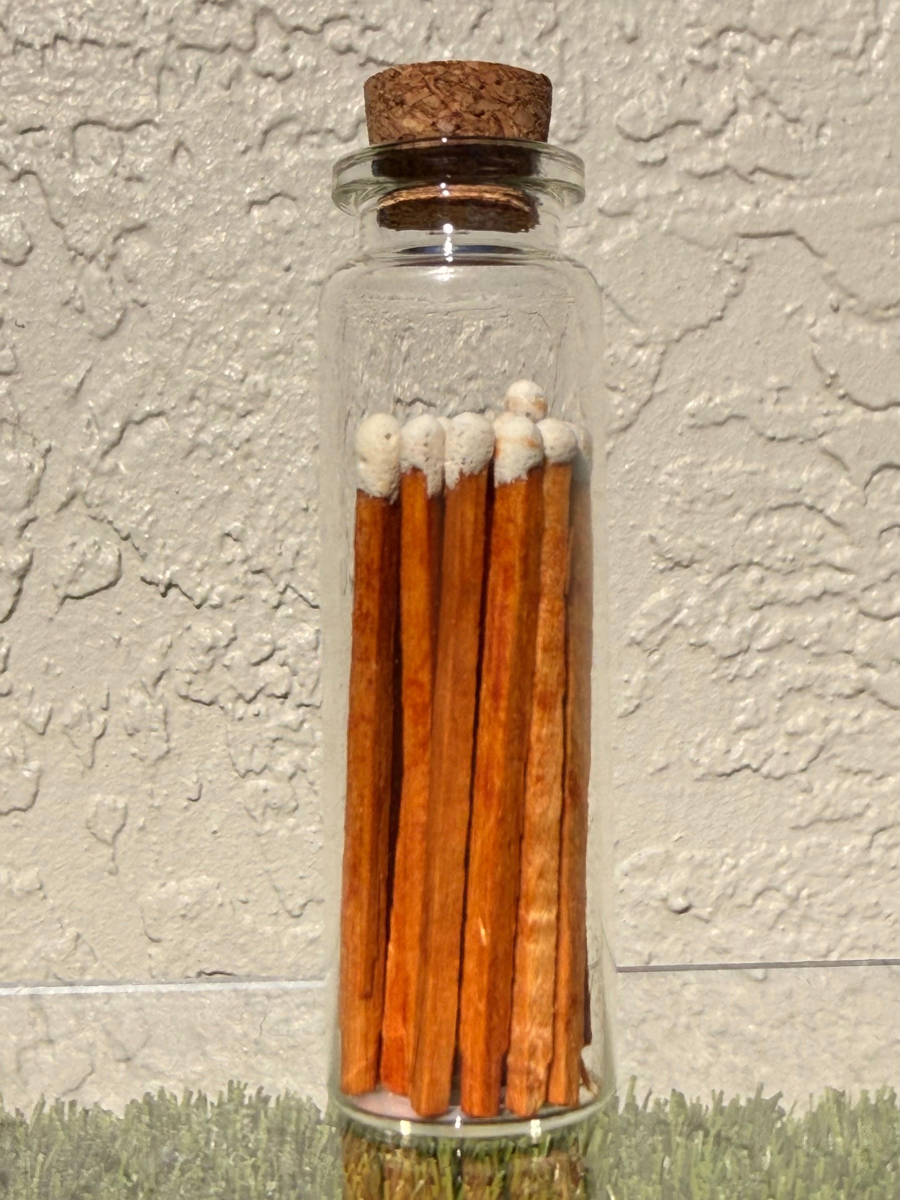 A picture of a glass jar of twenty matches with a cork top.