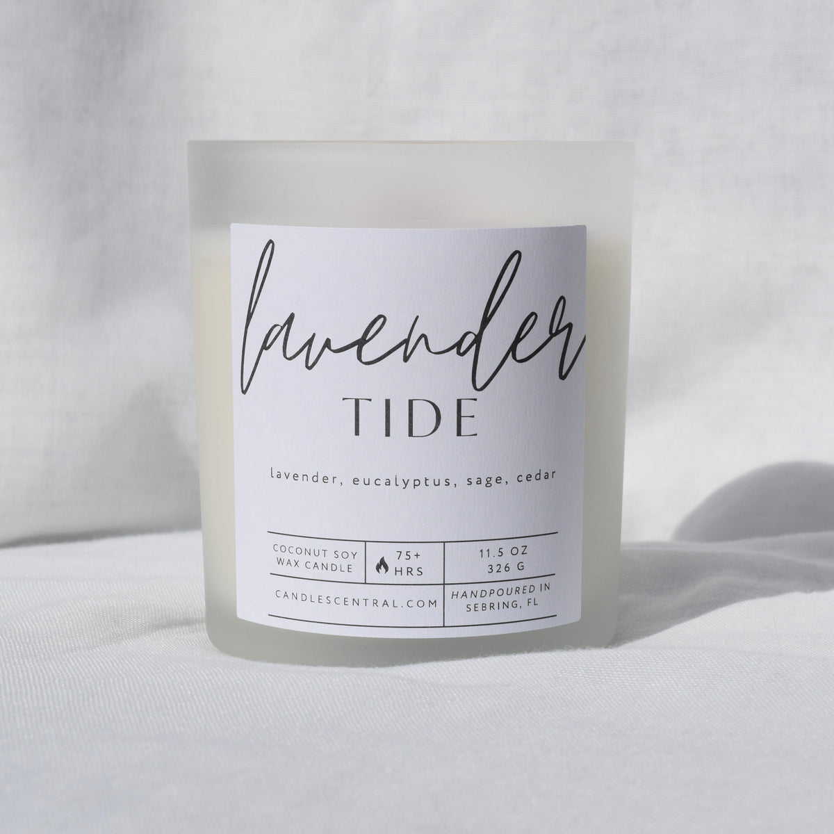Picture of a candle with a label that says "Lavender Tide" along with the fragrance notes of lavender, eucalyptus, sage, and cedar