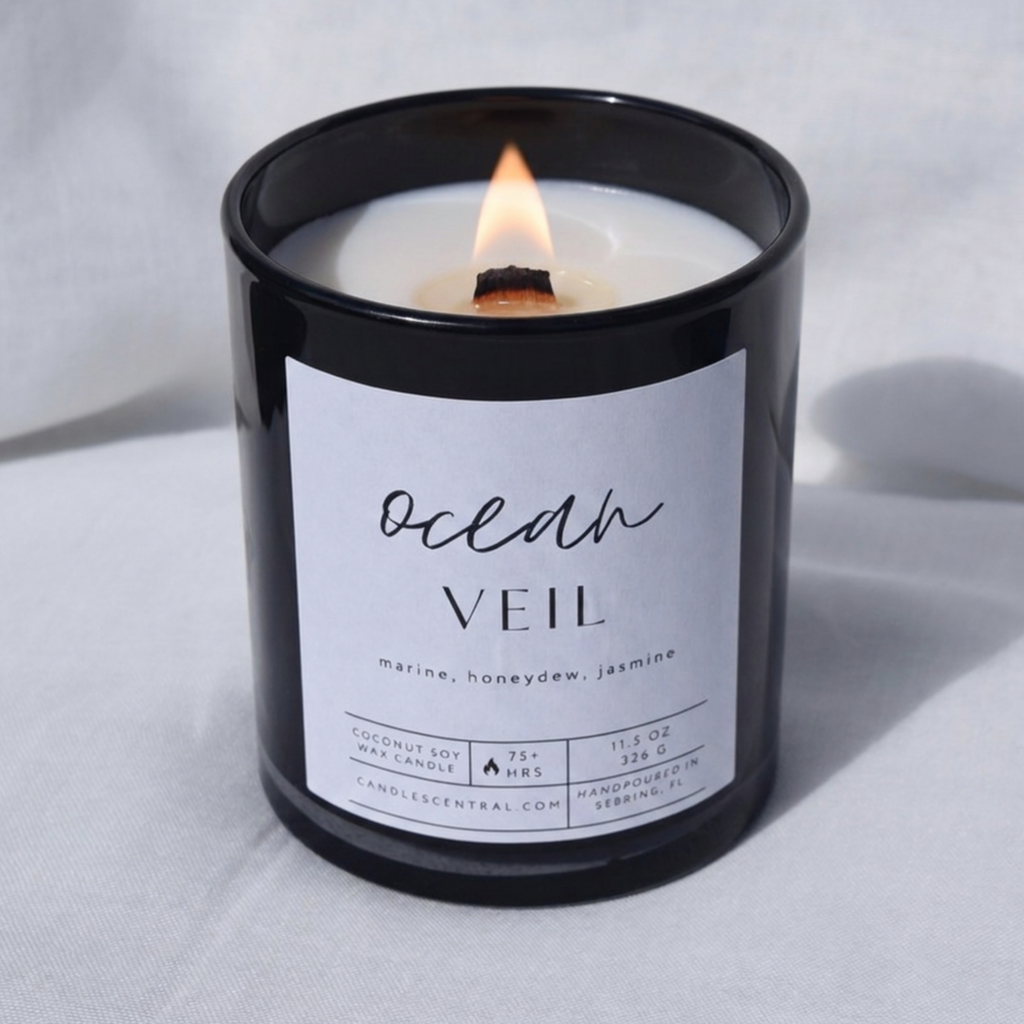 Picture of a candle burning with a label that says "Ocean Veil" along with the fragrance notes of marine, honeydew, and jasmine