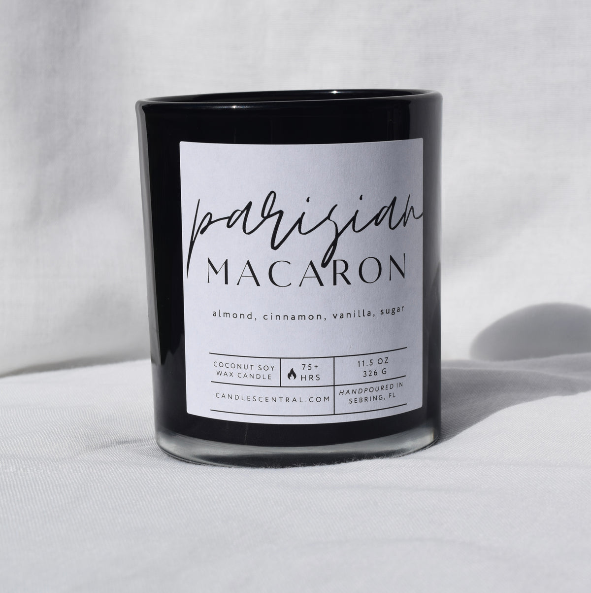 Picture of a candle with a label that says "Parisian Macaron" along with the fragrance notes of almond, cinnamon, vanilla, and sugar