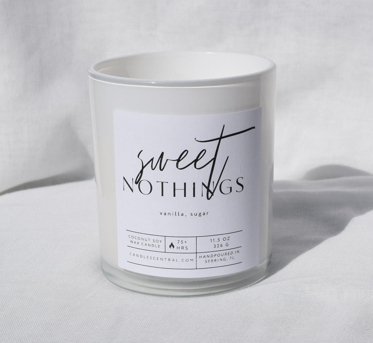 Picture of a candle with a label that says "Sweet Nothings" along with the fragrance notes of vanilla and sugar