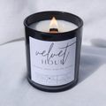 Picture of a candle burning with a label that says "Velvet Hour" along with the fragrance notes of bergamot, lemon, black tea, and lavender
