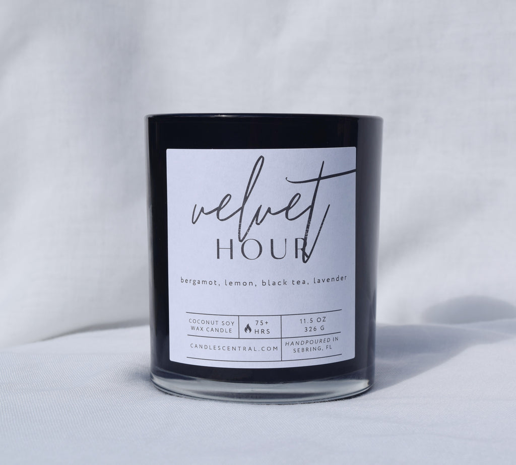 Picture of a candle with a label that says "Velvet Hour" along with the fragrance notes of bergamot, lemon, black tea, and lavender