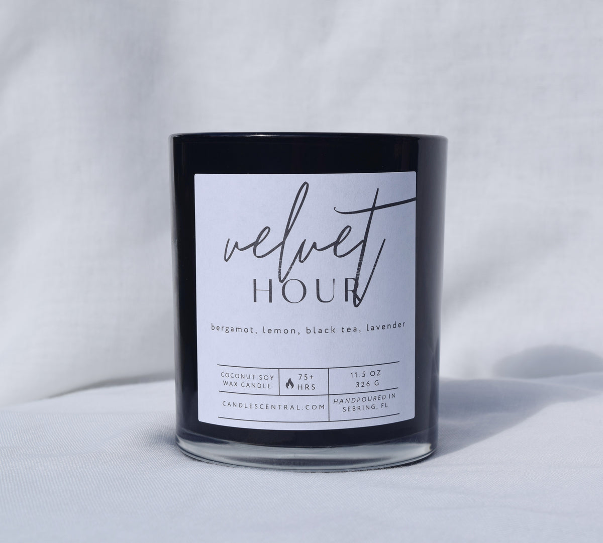 Picture of a candle with a label that says "Velvet Hour" along with the fragrance notes of bergamot, lemon, black tea, and lavender