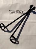 A picture of a black candle wick trimmer on a background that says "Candle Lab Sebring"